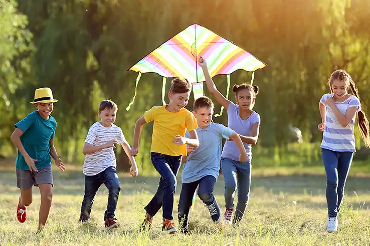 Children flying kite on summer day